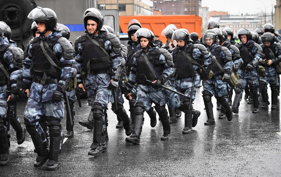 Servicemen of the Russian National Guard walk during a rally in central Moscow on August 10, 2019 after mass police detentions. On a rainy afternoon, protesters huddled under umbrellas on the central Prospekt Andreya Sakharova street, where city authorities had given permission for the rally to take place.