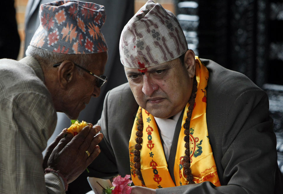 FILE - Nepal's former King Gyanendra, right, listens to a supporter on his 64th birthday at his residence in Kathmandu, Nepal, July 7, 2011. Nepal’s once unpopular monarchy — abolished after centuries of rule over the Himalayan nation — is hoping to regain some of its lost glory. Royalist groups and supporters of former King Gyanendra have been holding rallies to demand the restoration of the monarchy and the nation’s former status as a Hindu state. (AP Photo/Binod Joshi, File).
