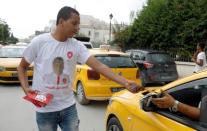 A supporter of presidential candidate Nabil Karoui distributes leaflets during a campaign in Tunis