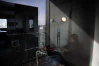 Lina Maria Fajardo of Colombia, a student in psychiatry of elderly people is seen through a window as she studies in her student housing in Ivry sur Seine, outside Paris, Thursday, Feb. 11, 2021. A quarter of French young professionals can't find work, and many university students are standing in food lines or calling hotlines for psychological help. They are France's future, and their plight is central to the country's battle to emerge from the pandemic. (AP Photo/Christophe Ena)