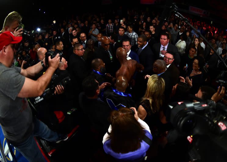 Bernard Hopkins arises amid a sea of people at ringside after getting knocked through the ropes in the eighth round Saturday by Joe Smith Jr. (Getty Images)