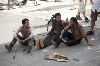<p>Knives and crossbows and machetes, oh my! Steven Yeun, Norman Reedus, and Andy Lincoln take a break and share a laugh at the prison set.<br><br>(Photo: AMC) </p>