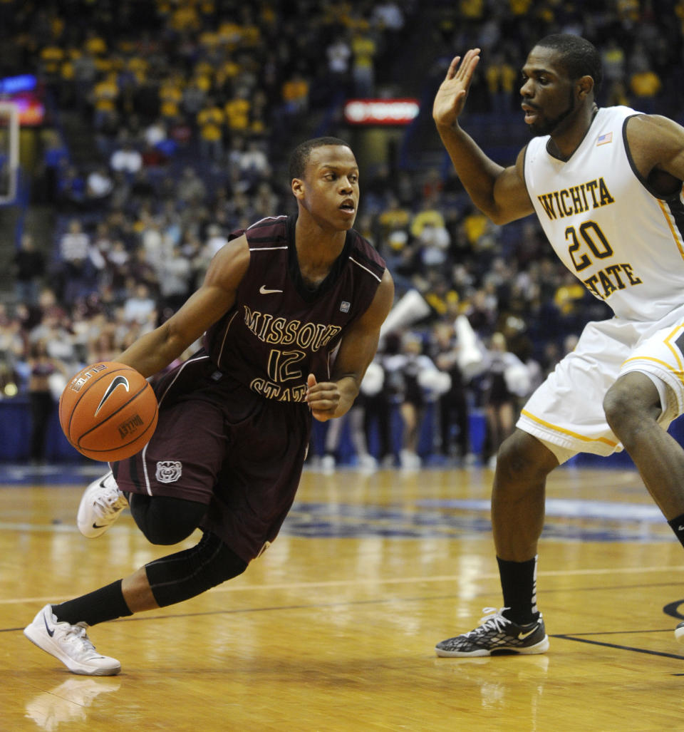 Missouri State's Devon Thomas (12) drives past Wichita State's Kadeem Coleby (20) in the first half of an NCAA college basketball game in the semifinals of the Missouri Valley Conference men's tournament, Saturday, March 8, 2014, in St. Louis. (AP Photo/Bill Boyce)