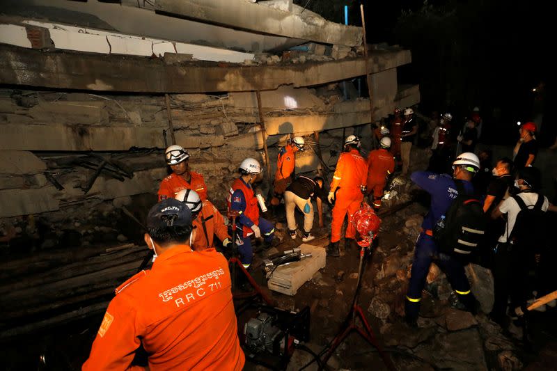 A rescue team searches for trapped workers at a collapsed building, which was under construction in Kep, Cambodia