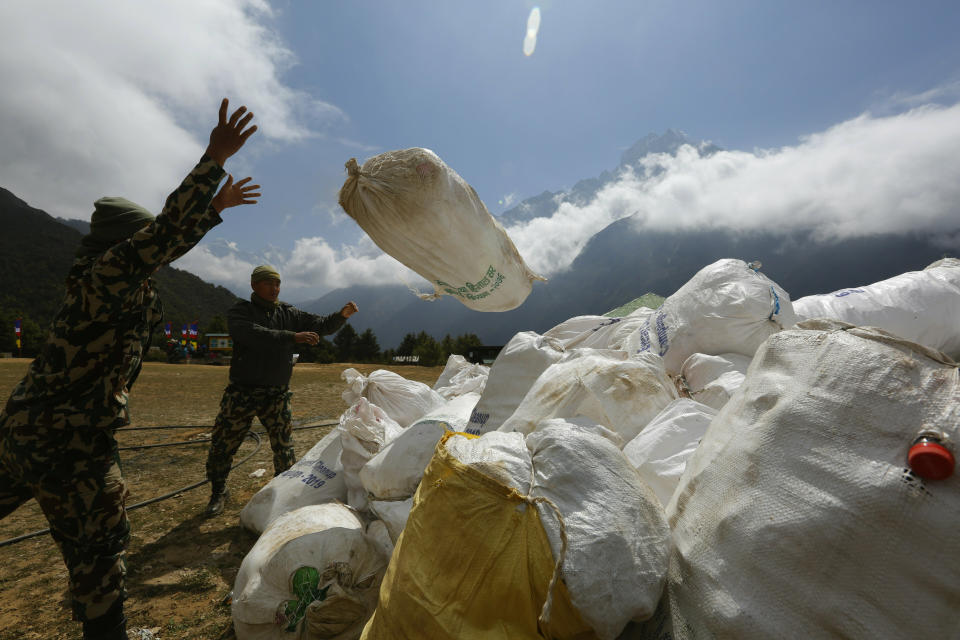 In this May 27, 2019 photo, Nepalese army men pile up the garbage collected from Mount Everest in Namche Bajar, Solukhumbu district, Nepal. The record number of climbers on Mount Everest this season has left a cleanup crew grappling with how to clear away everything from abandoned tents to human waste that threatens drinking water. (AP Photo/Niranjan Shrestha)