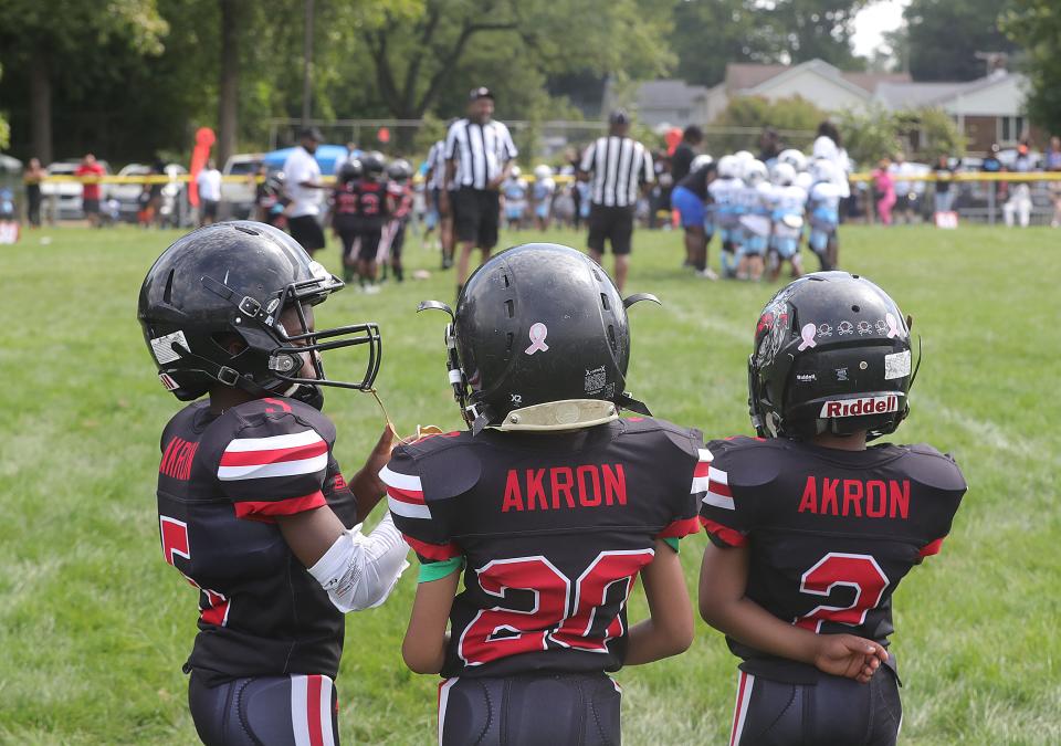 Akron Rubber City Kings pee wee football players wait to start playing Sunday at Erie Island Park in Akron.