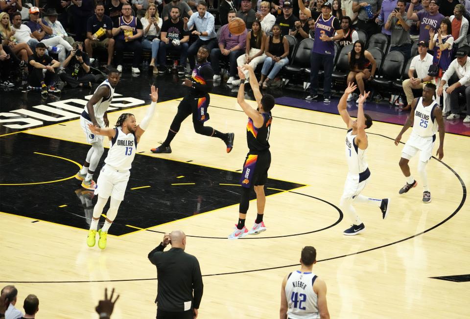 May 10, 2022; Phoenix, Arizona, USA; Phoenix Suns guard Devin Booker (1) makes a three-pointer against Dallas Mavericks guard Jalen Brunson (13) during game five of the second round for the 2022 NBA playoffs at Footprint Center.