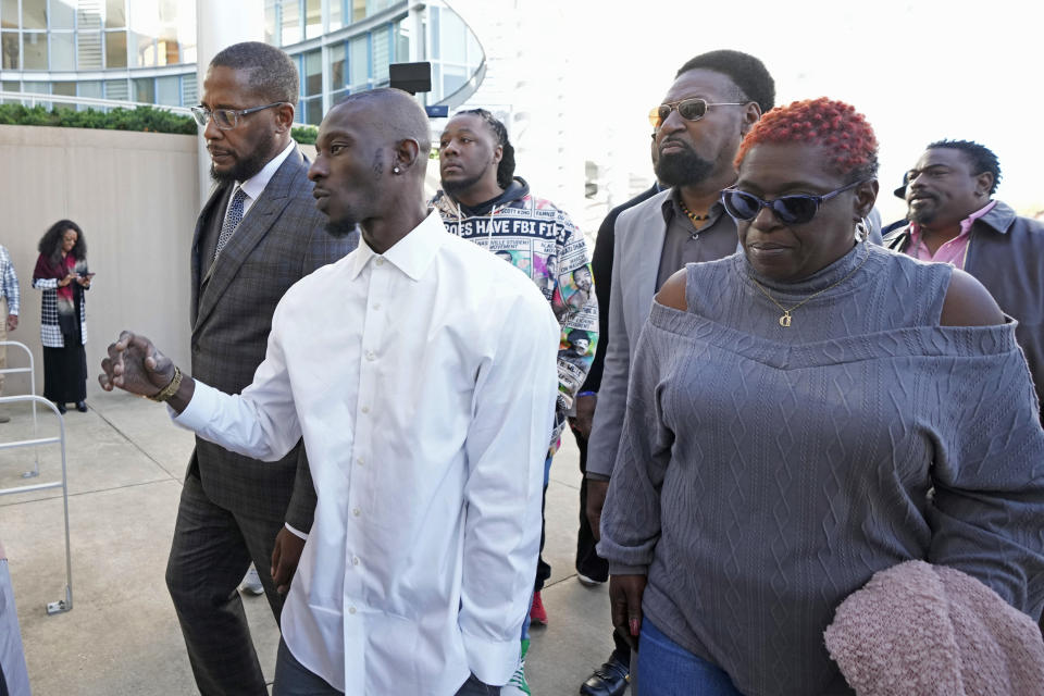 Michael Corey Jenkins, second from left, and attorney Malik Shabazz, left, are joined by supporters as they enter the Thad Cochran United States Courthouse in Jackson, Miss., Tuesday, March 19, 2024, for sentencing on two of the six former Mississippi Rankin County law enforcement officers who committed numerous acts of racially motivated, violent torture on Jenkins and his friend Eddie Terrell Parker in 2023. The six former law officers pleaded guilty to a number of charges for torturing them and sentencing begins Tuesday in federal court. (AP Photo/Rogelio V. Solis)