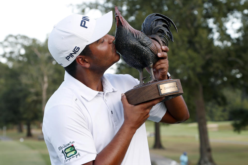 Sebastian Munoz, of Colombia, kisses the trophy after winning the Sanderson Farms Championship golf tournament in Jackson, Miss., Sunday, Sept. 22, 2019. (AP Photo/Rogelio V. Solis)