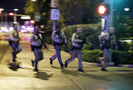 <p>Police run to cover at the scene of a shooting near the Mandalay Bay resort and casino on the Las Vegas Strip, Oct. 1, 2017, in Las Vegas. Multiple victims were being transported to hospitals after a shooting late Sunday at a music festival on the Las Vegas Strip. (Photo: John Locher/AP) </p>