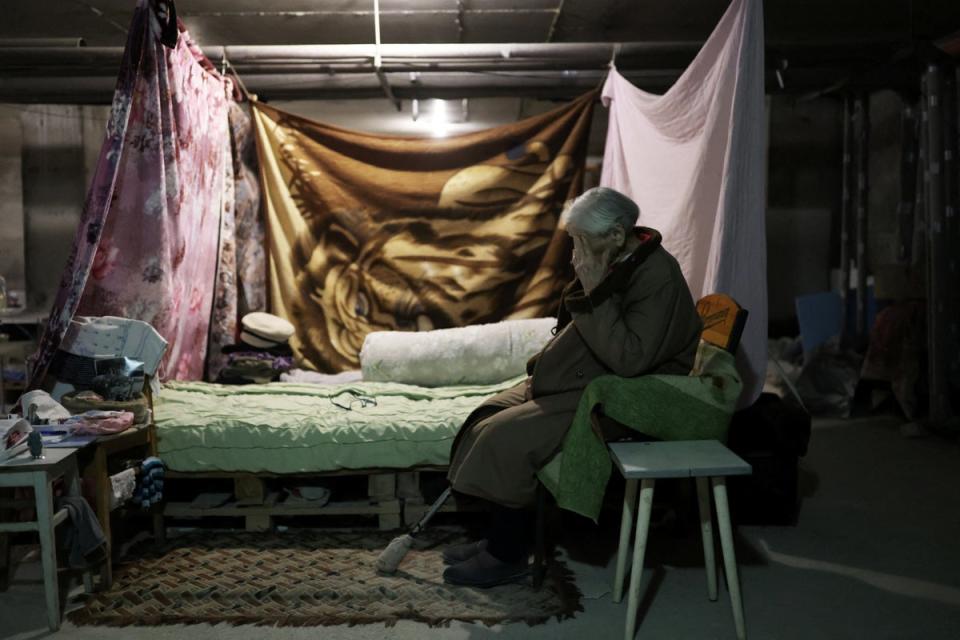 Maria gestures next to her makeshift bedroom inside a basement (Reuters)