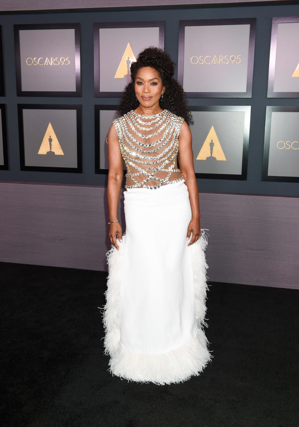 Angela Bassett in a white skirt and a sheer crystal top