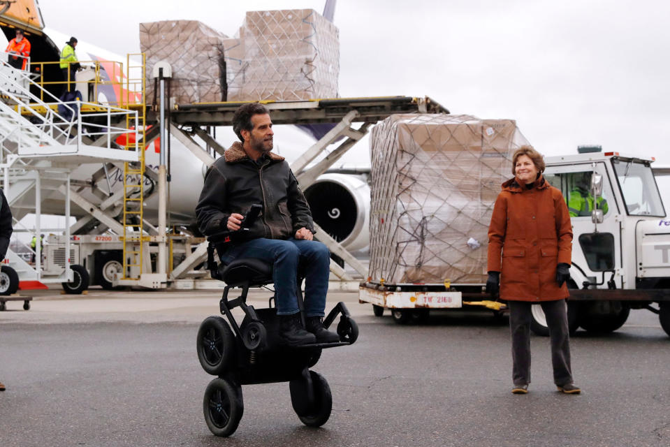 U.S. Sen. Jeanne Shaheen (D-NH), right, looks toward inventor Dean Kamen as over 110,000 pounds of personal protective equipment (PPE) from Shanghai, China, delivered to protect medical workers and first responders fighting the COVID-19 virus outbreak, is unloaded from a cargo plane at Manchester-Boston Regional Airport in Manchester, New Hampshire, Thursday, April 30, 2020