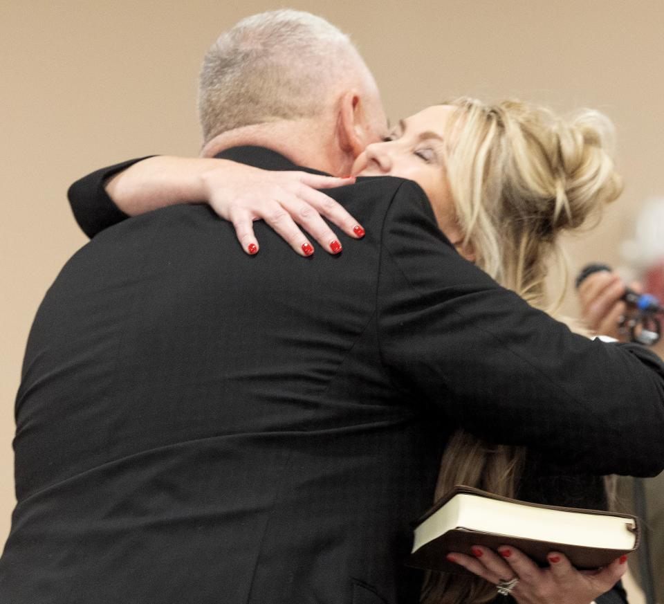 Jamie Slutz is hugged by his wife, Christie Slutz, after being sworn in Saturday night as Massillon's new mayor.
