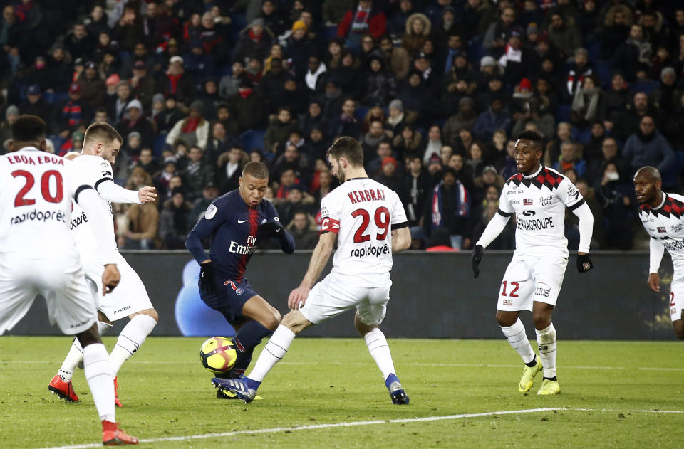 PSG's Kylian Mbappe, center left, tries to get past Guingamp's Christophe Kerbrat during the League One soccer match between Paris Saint Germain and Guingamp at the Parc des Princes stadium in Paris, Saturday, Jan. 19, 2019. (AP Photo/Michel Euler)