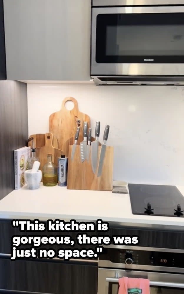 A well-organized kitchen counter with cutting boards, knives, and oil bottles; quote praises kitchen's beauty