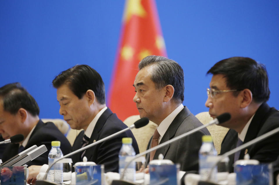 China's Foreign Minister Wang Yi, second from right, attends the Japan-China high level economic dialogue with Japanese Foreign Minister Taro Kono at Diaoyutai State Guesthouse in Beijing, China, Sunday, April 14, 2019.(Jason Lee/Pool Photo via AP)