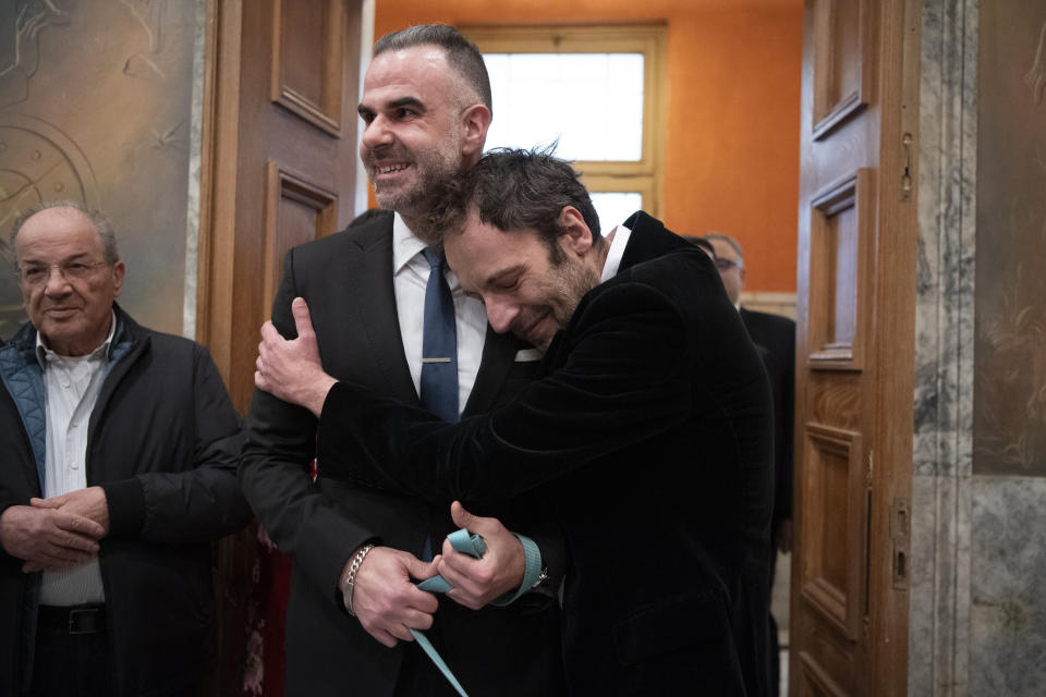 Greek author Petros Hadjopoulos, who uses the pen name Auguste Corteau, hugs his husband, lawyer Anastasios Samouilidis, before their wedding at Athens City Hall, Greece, on Thursday, March 7, 2024. 