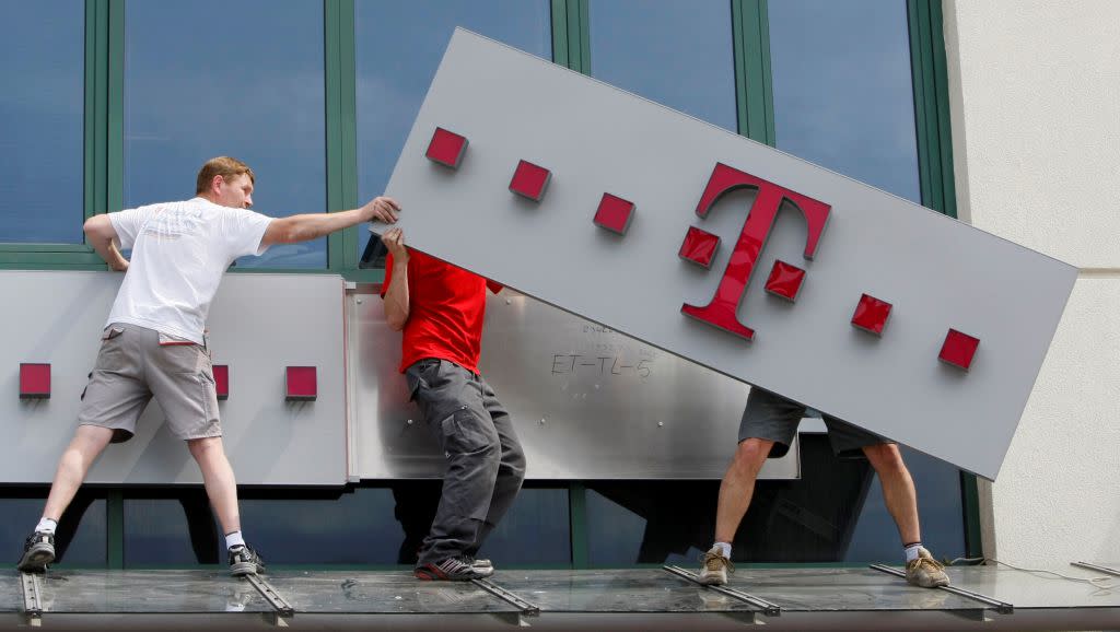 Workers redecorate a former Era Mobile phone outlet with T-Mobile logo in Warsaw