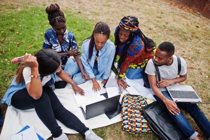 A group of students sitting around in front of laptops