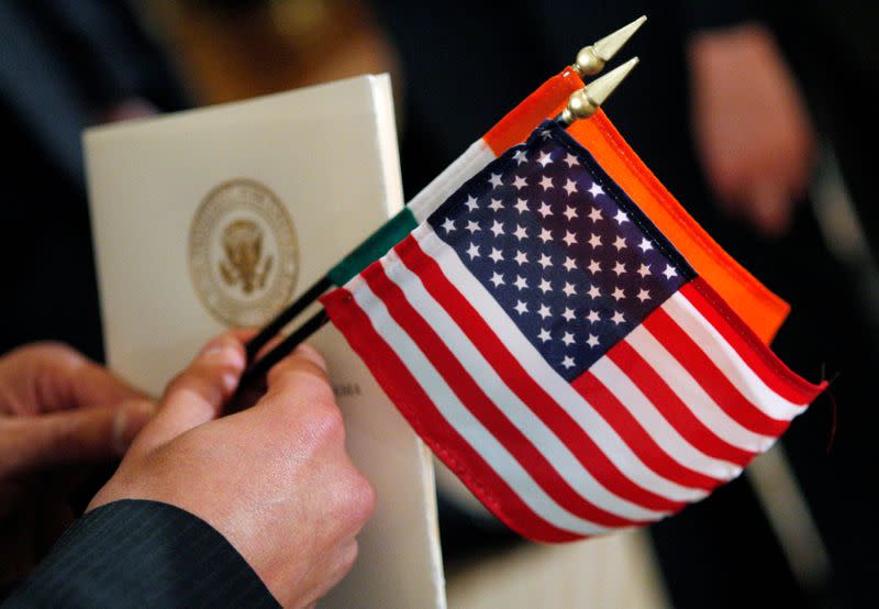 A guest holds the flags of the United States and India as Obama welcomes Singh at an official arrival ceremony at the White House in Washington