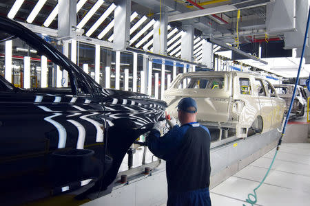 FILE PHOTO: A Ford worker inspects paint work on the body of a Ford Expedition SUV at Ford's Kentucky Truck Plant as the No. 2 U.S. automaker ramps up production of two large SUV models in Louisville, Kentucky, U.S., February 9, 2018. REUTERS/Nick Carey/File Photo