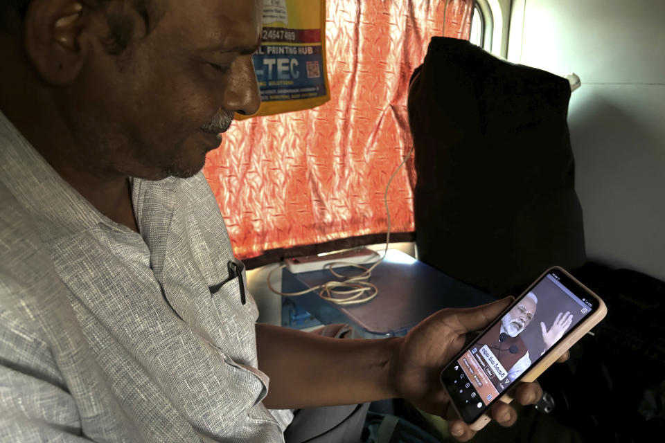 A passenger watches videos of Indian prime minister Narendra Modi while traveling in the Thirukkural Express, India, Sunday, April 21, 2024. (AP Photo/Manish Swarup)