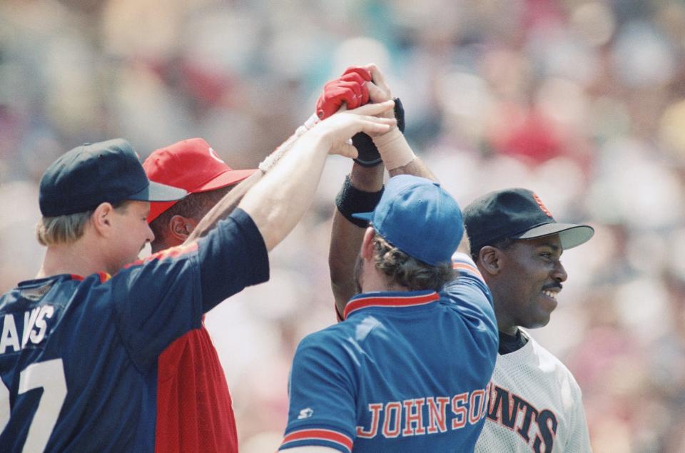 National League players Glenn Davis of the Houston Astros, Eric Davis of the Cincinnati Reds, Howard Johnson of the New York Mets and Kevin Mitchell of the San Francisco Giants celebrate after winning the 1989 home run contest before the All-Star Game.