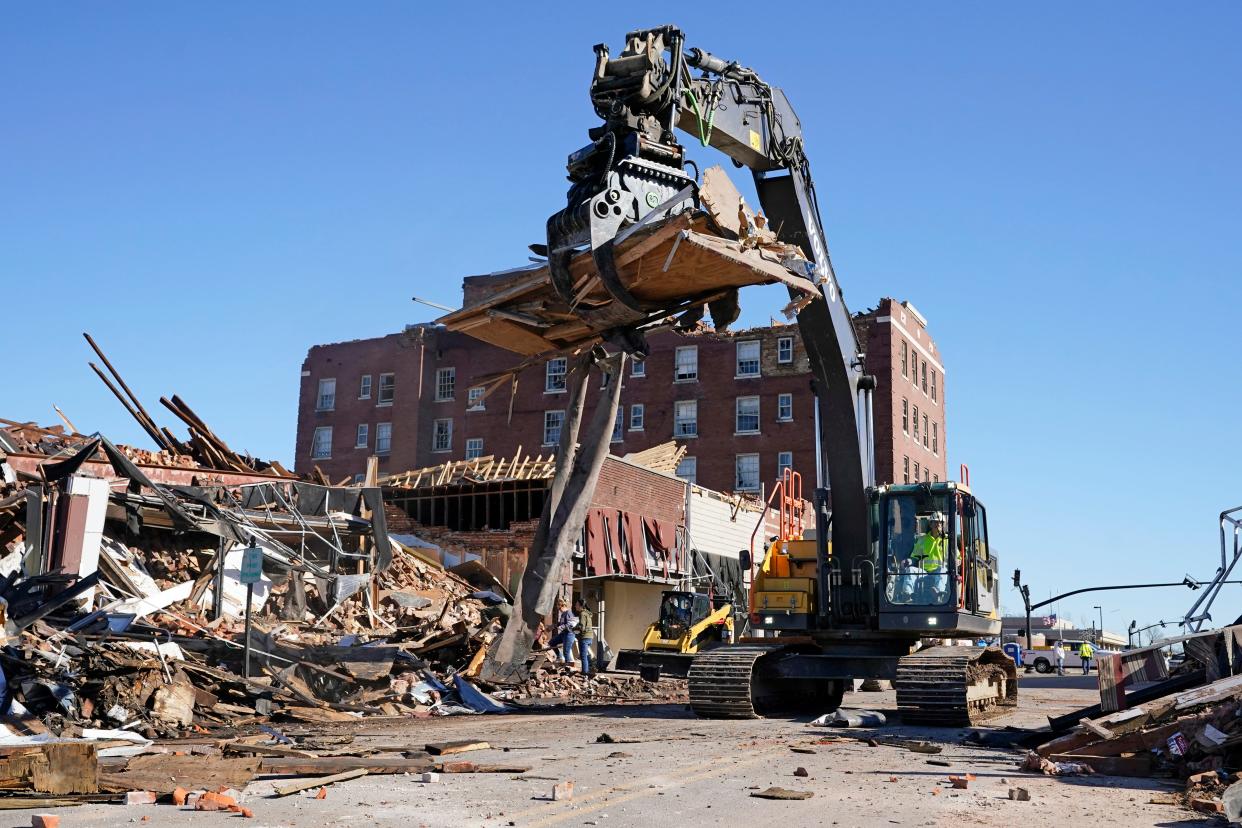 Workers remove debris from destroyed buildings Sunday, Dec. 12, 2021, in Mayfield, Ky. Tornadoes and severe weather caused catastrophic damage across several states Friday, killing multiple people overnight. 