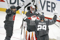 Calgary Flames goalie David Rittich (33) celebrates with Calgary Flames defender Mark Giordano, left, and Edmonton Oilers forward Leon Draisaitl (29) after the Pacific Division defeated the Atlantic Division 5-4 in the NHL hockey All Star final game Saturday, Jan. 25, 2020, in St. Louis. (AP Photo/Scott Kane)