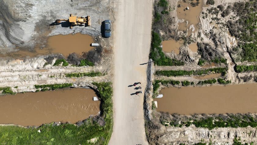 Allensworth, CA, Saturday, March 18, 2023 - Allensworth residents walk past a levy they worked to fortify instead of waiting for government agencies to prevent floodwaters from inundating their community. (Robert Gauthier/Los Angeles Times)