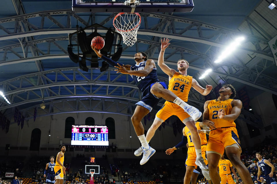 Villanova's Jermaine Samuels, left, goes up for a shot past La Salle's Christian Ray during the first half of an NCAA college basketball game, Sunday, Nov. 28, 2021, in Philadelphia. (AP Photo/Matt Slocum)