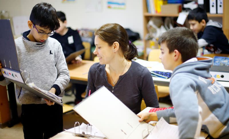 FILE PHOTO: Children of a welcome class for migrants attend a German language lesson at the catholic Sankt Franziskus school in Berlin