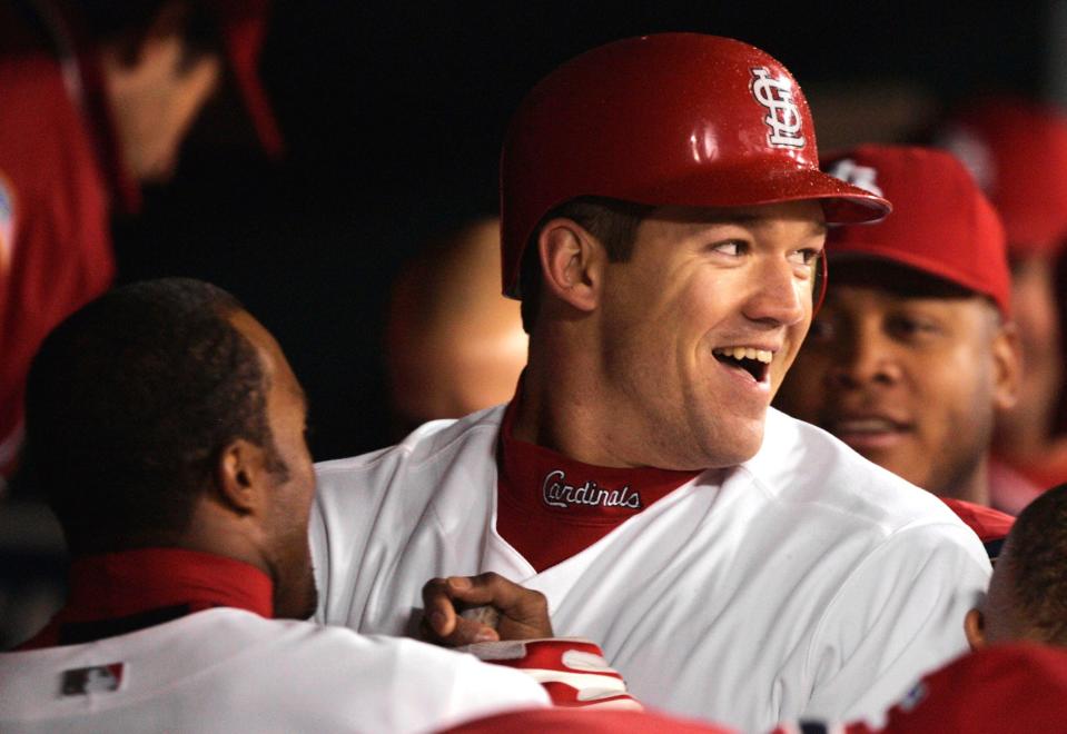 St. Louis Cardinals' Scott Rolen is welcomed to the dugout after his eighth inning solo home run against the Houston Astros in  Game 2 of the National League Championship Series, Thursday, Oct. 14, 2004, in St. Louis. Rolen's homer followed teammate Albert Pujols solo shot and the Cardinals won, 6-4, to take a 2-0 lead in the series.