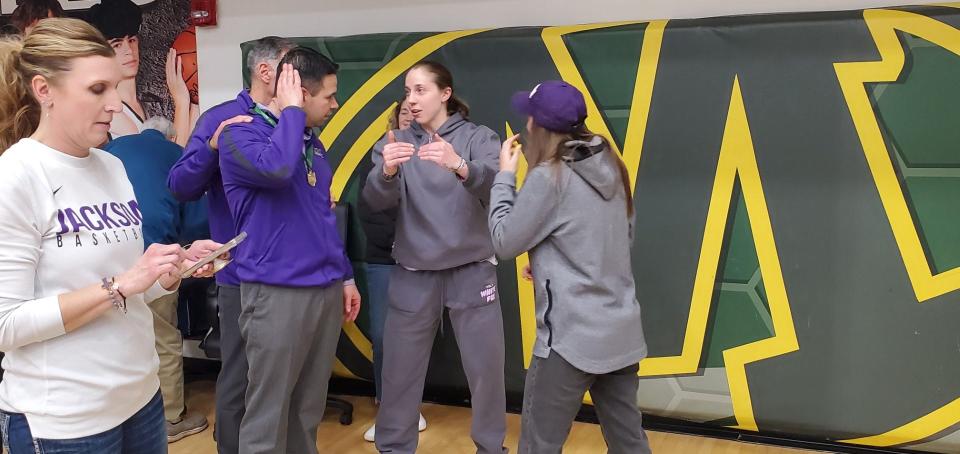 Jackson girls basketball coach Anthony Butch (second from left) talks with former Polar Bears star and current WNBA player Taylor Mikesell (second from right) at Medina High School this season.