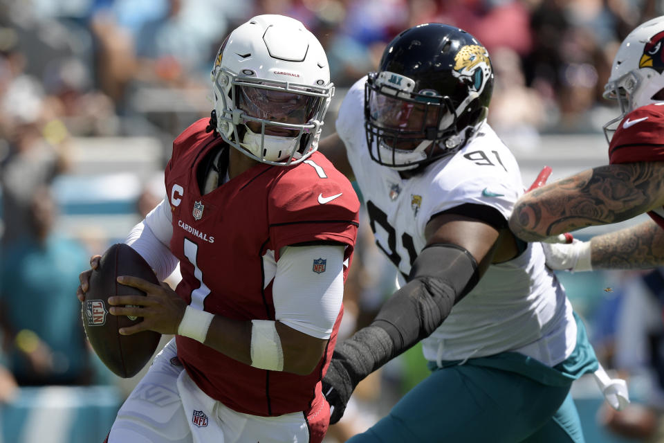 Arizona Cardinals quarterback Kyler Murray (1) scrambles way from Jacksonville Jaguars defensive end Dawuane Smoot (91) during the first half of an NFL football game, Sunday, Sept. 26, 2021, in Jacksonville, Fla. (AP Photo/Phelan M. Ebenhack)