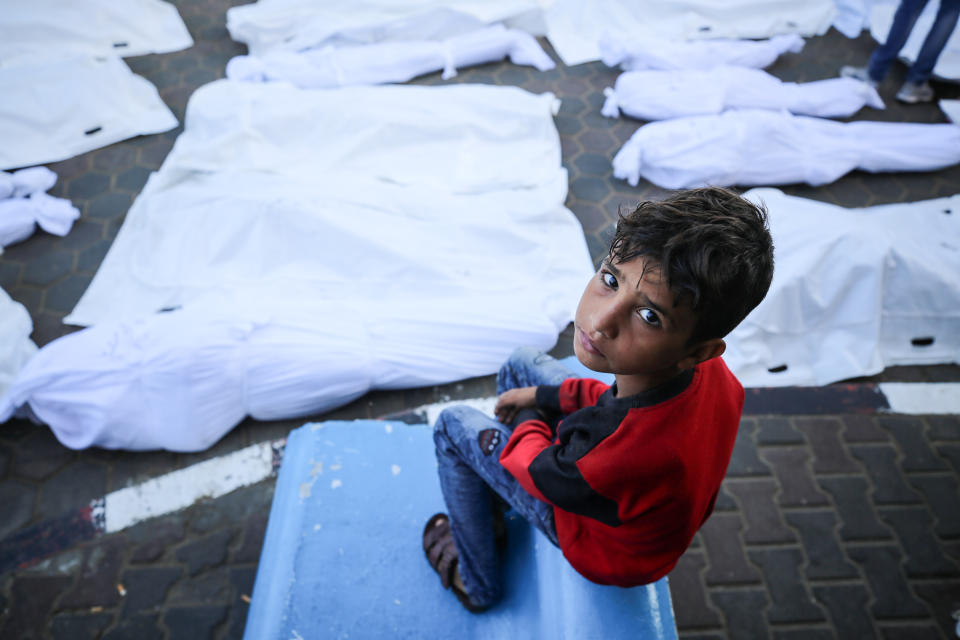 A child sits near bodies of those killed by an Israeli airstrike in Deir Balah, central Gaza, on Monday. (Majdi Fathi/NurPhoto via Getty Images)