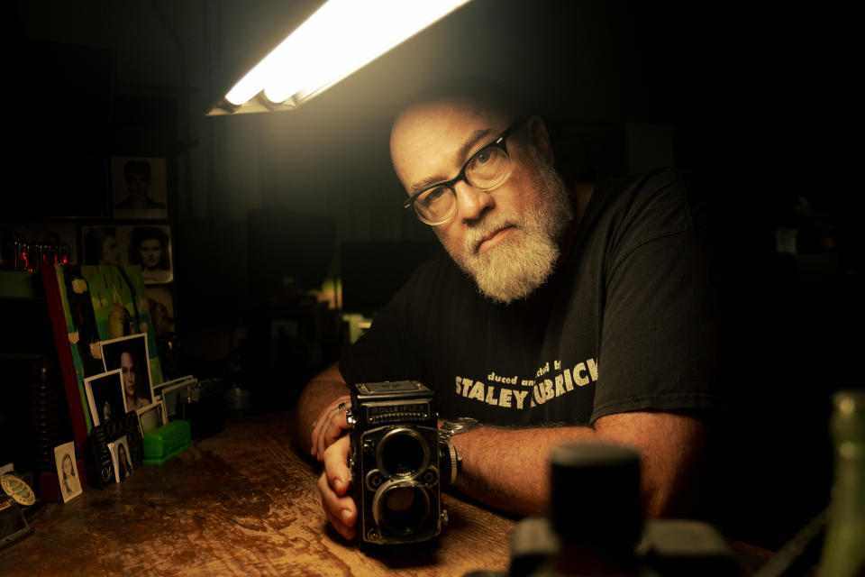 Dan sitting at his desk with an old Rolleiflex camera. (National Geographic/David Fausto)