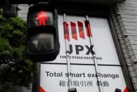 The Tokyo Stock Exchange (TSE) logo is seen next to a traffic light after the TSE temporarily suspended all trading due to system problems in Tokyo