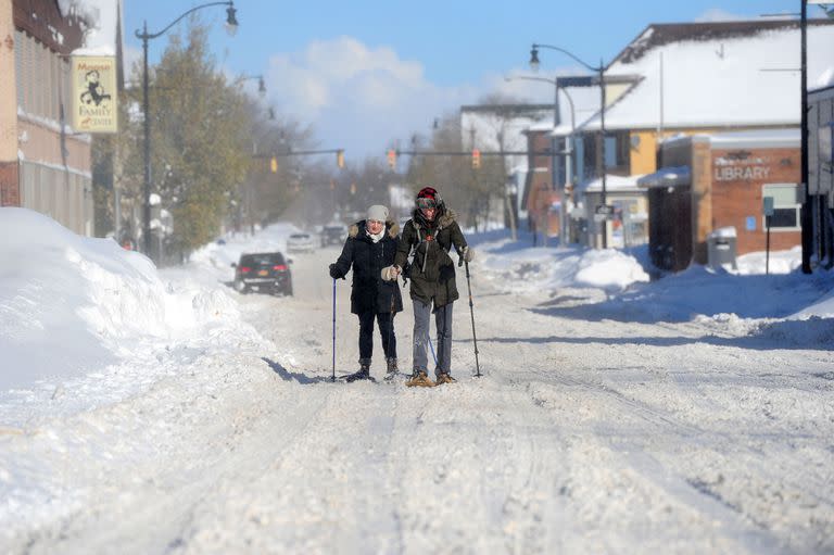 Megan Barr y Amanda Johnston caminan con raquetas de nieve por las calles el 20 de noviembre de 2022 en Búfalo, Nueva York.