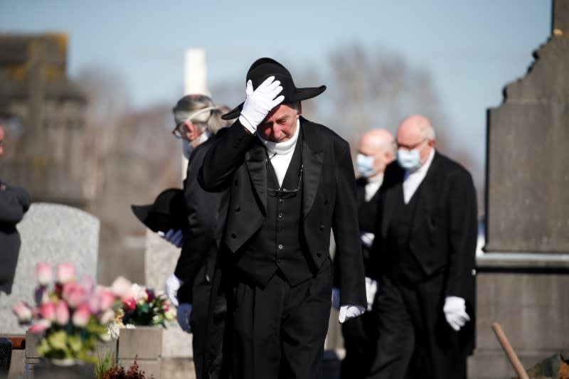 Members of the Charitable Brotherhood which first formed during the plague 800 years ago, attend a burial ceremony in Bethune