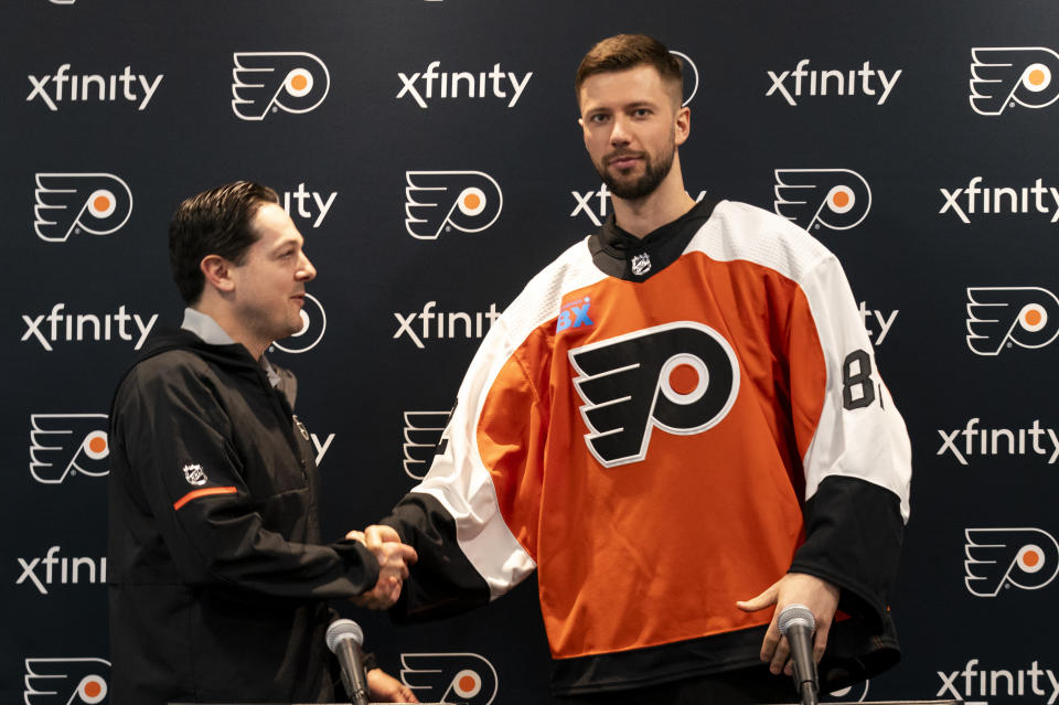 Philadelphia Flyers' Ivan Fedotov, right, shakes hands with general manager Daniel Briere during an NHL hockey press conference, Friday, March 29, 2024, in Voorhees, N.J. (AP Photo/Chris Szagola)