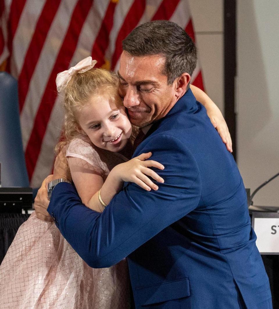 New Miami Beach Commissioner Joseph Magazine hugs his daughter Capri during a swearing-in ceremony at the Miami Beach Convention Center, Tuesday, November 28, 2023.