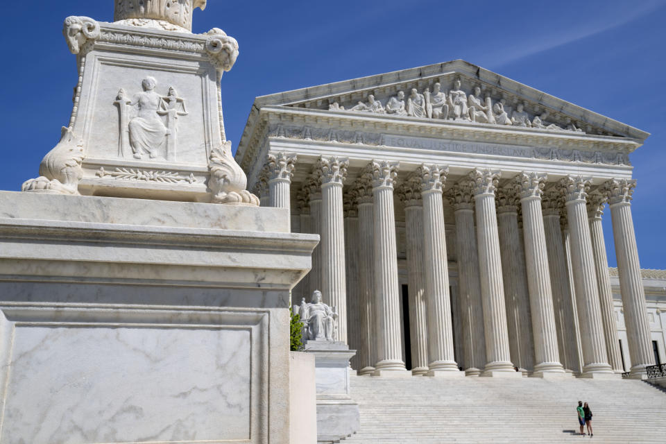 FILE - The Supreme Court is seen, with a carving of Justice in the foreground, April 19, 2023, in Washington. The Supreme Court is facing a self-imposed Friday night deadline to decide whether women’s access to a widely used abortion pill will stay unchanged until a legal challenge to its Food and Drug Administration approval is resolved. (AP Photo/Jacquelyn Martin, File)