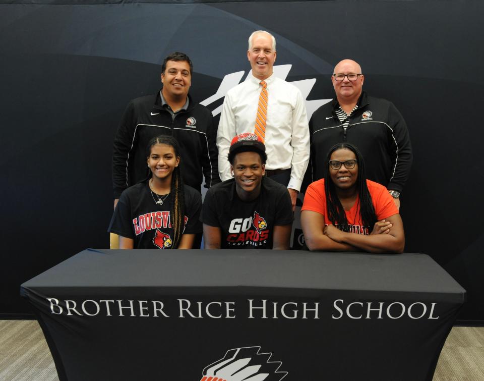 Brother Rice boys basketball star Curtis Williams (bottom middle) commits to Louisville on Monday, Sept. 19, 2022. He's flanked by (back, l-r) coach Rick Palmer, principal Ed Okuniewski, athletic director Jeff Calcaterra, sister Alexis Jones (bottom left) and mother Rhea Rogers (bottom right).