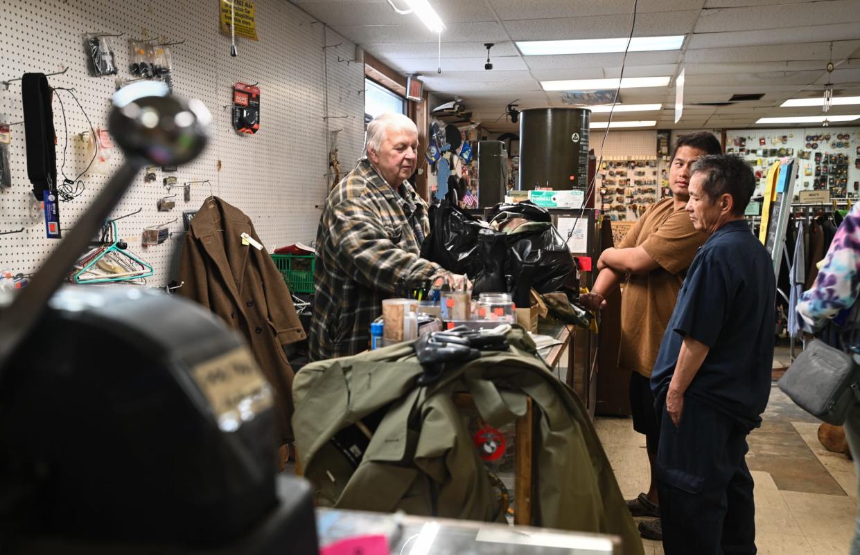 "Everyone hates to see this store go, but we want to travel and spend time with our grandkids," Foxhole PX Store owner Tim Carpenter says, Tuesday, May 7, 2024, as he cashes out Kong and Chong Thao, right, of Lansing. The store will close permanently on Saturday.