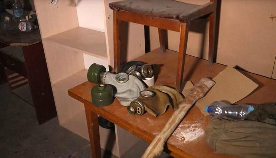 Gas masks and a wooden club, allegedly among the items used by occupying Russian forces to torture prisoners, are seen in the basement of the police station in Izyum, a town in northeast Ukraine recently reclaimed by Ukrainian forces, in September 2022.  / Credit: CBS News