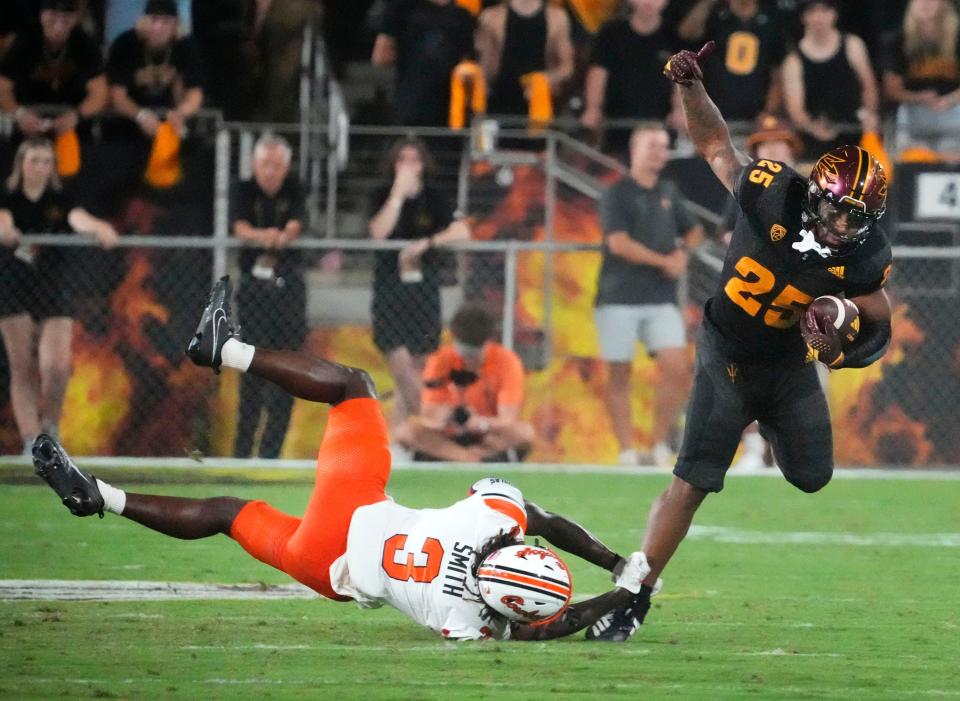 Oklahoma State Cowboys cornerback Cam Smith (3) tackles <a class="link " href="https://sports.yahoo.com/ncaaw/teams/arizona-st/" data-i13n="sec:content-canvas;subsec:anchor_text;elm:context_link" data-ylk="slk:Arizona State Sun Devils;sec:content-canvas;subsec:anchor_text;elm:context_link;itc:0">Arizona State Sun Devils</a> running back DeCarlos Brooks (25) in the second half at Mountain America Stadium in Tempe on Sept. 9, 2023.