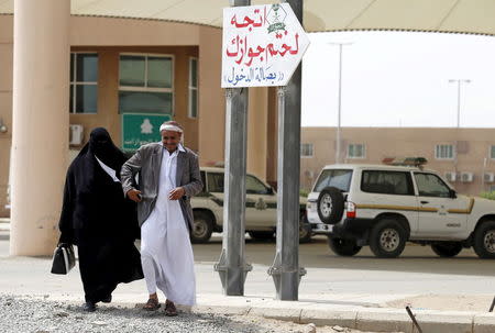 A Yemeni man walks with his wife as they arrive to stamp their passports to enter Saudi Arabia at Al-Tiwal crossing in Jizan on Saudi Arabia's border with Yemen, April 7, 2015. REUTERS/Faisal Al Nasser