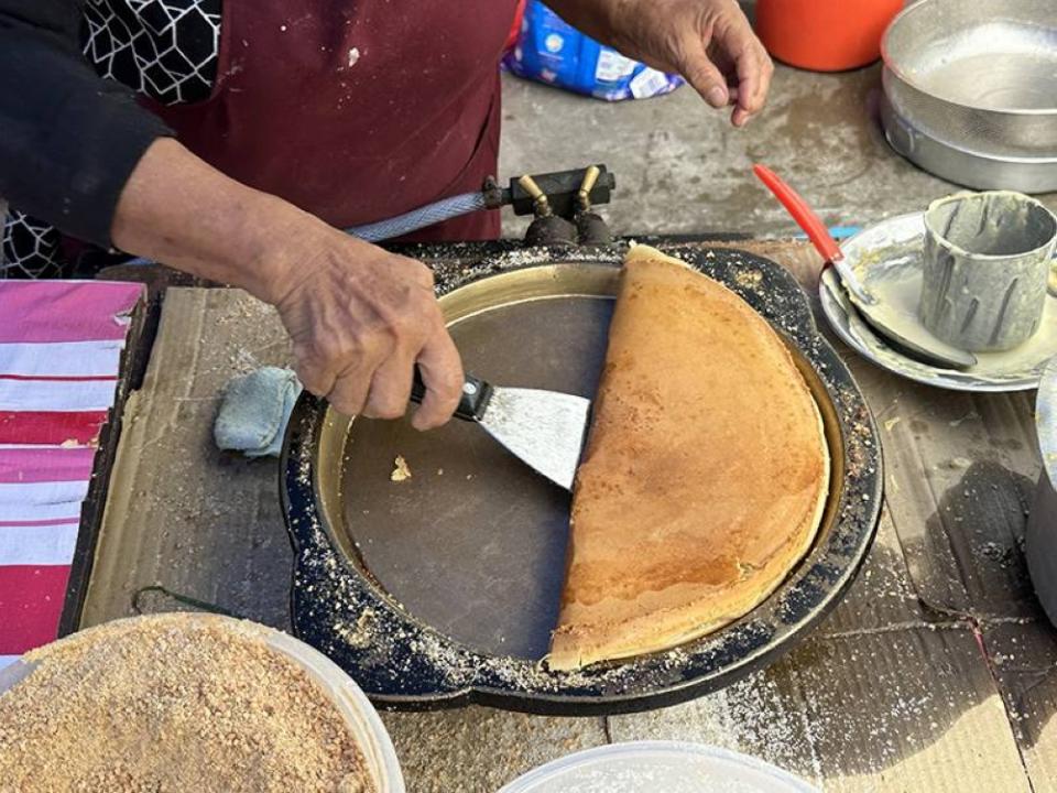 Once the 'apam balik' is cooked, it is folded in half and removed from the pan.